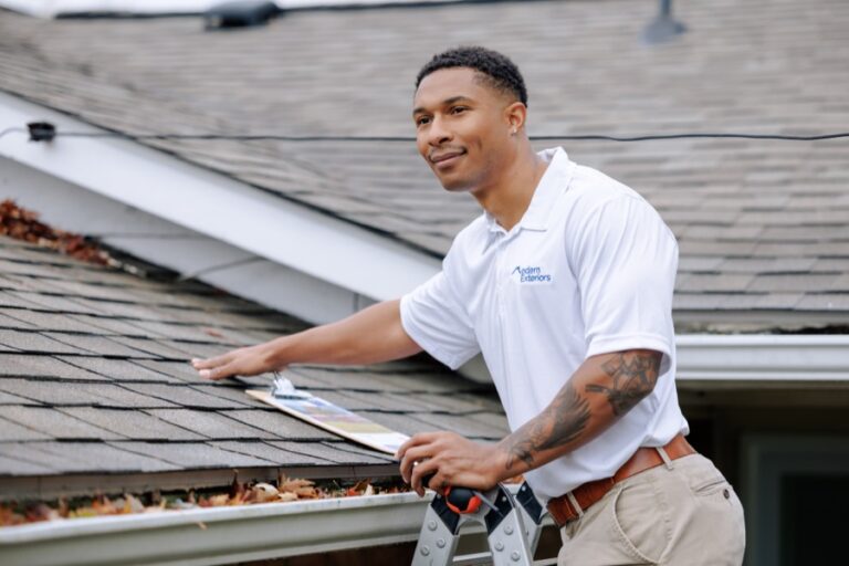 Roofing professional inspecting shingles on a Wilmington Delaware home