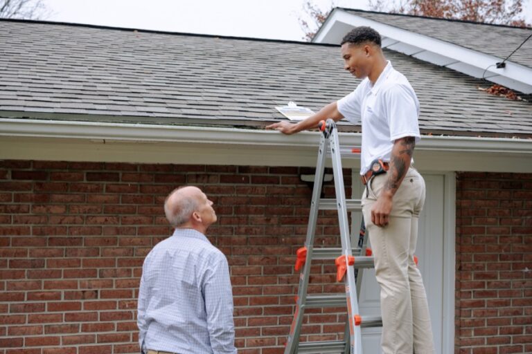 Crew members inspecting gutter and roofline together