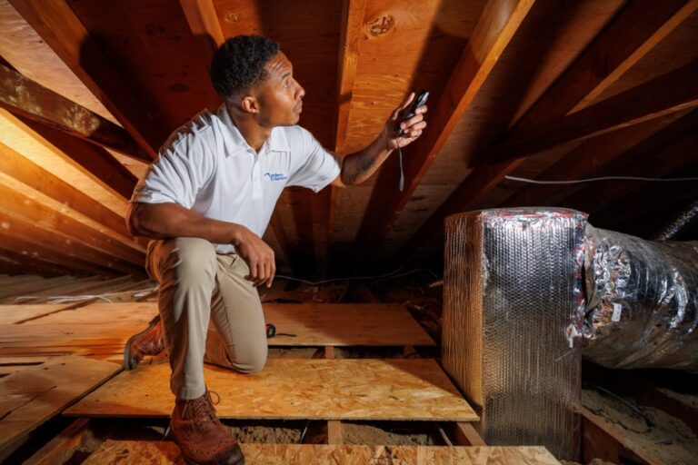 Technician inspecting attic insulation and ductwork