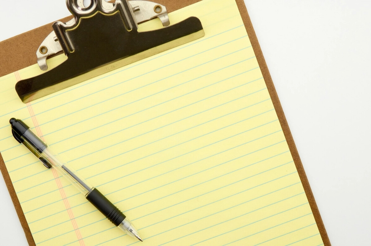 Blank clipboard, notepad, and pen representing a signed roof certification document