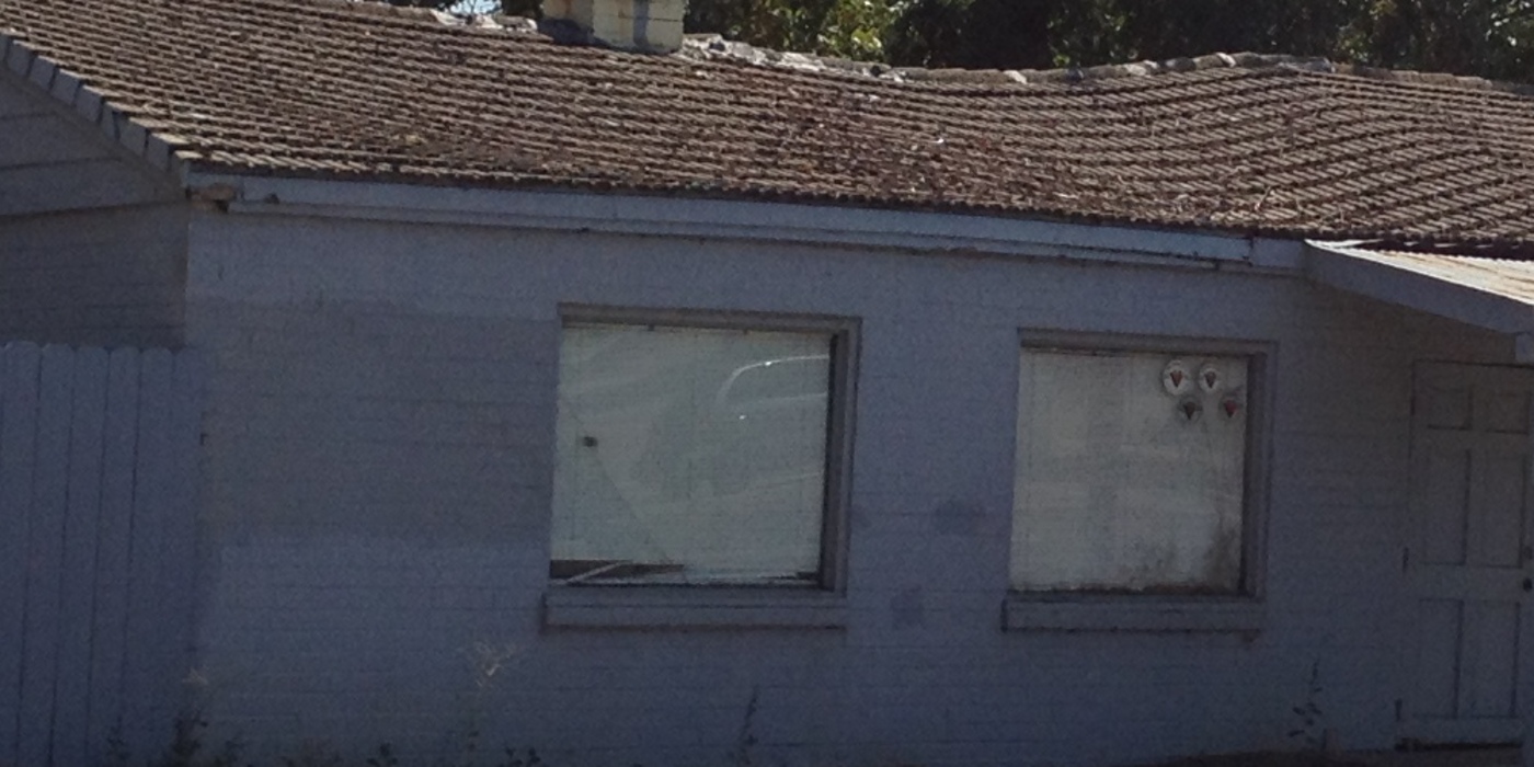 Roofline of a house showing a visibly uneven, sagging ridge along the roof deck